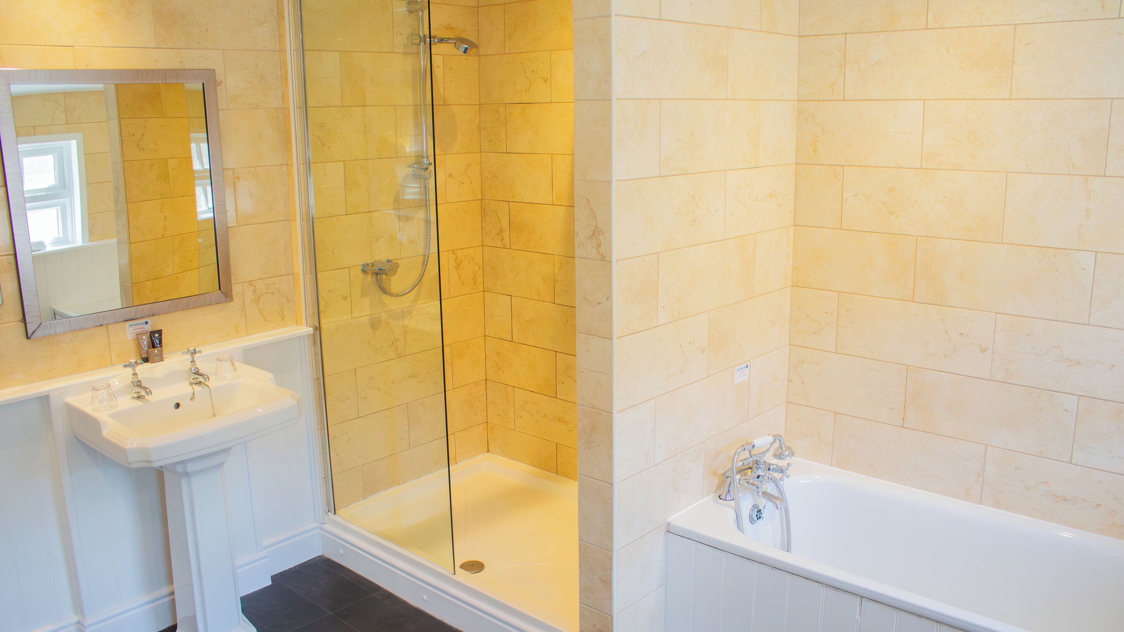 A bathroom with a glass-enclosed shower, a sink, and a bathtub.
