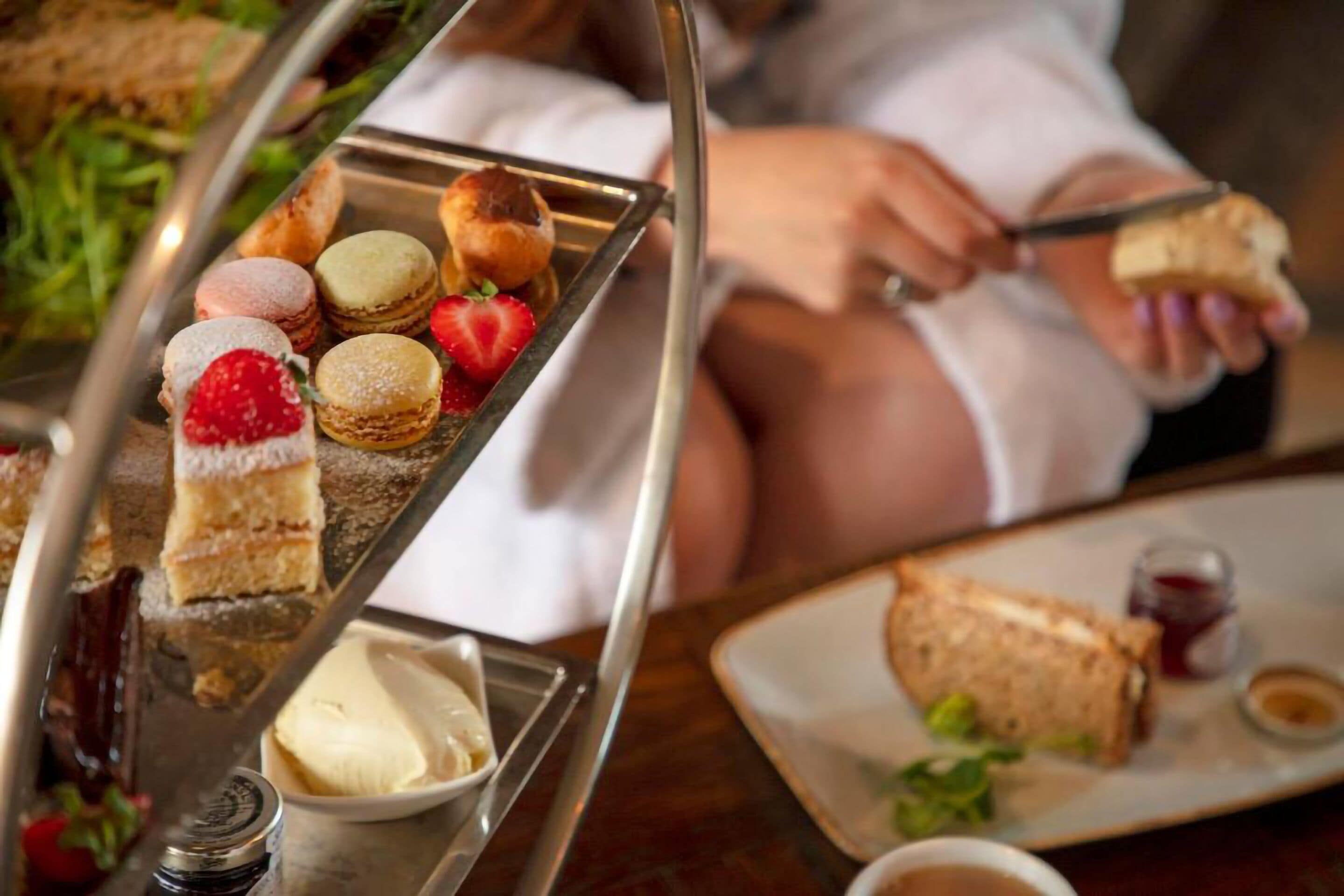 A tray of assorted pastries and a sandwich on a table.