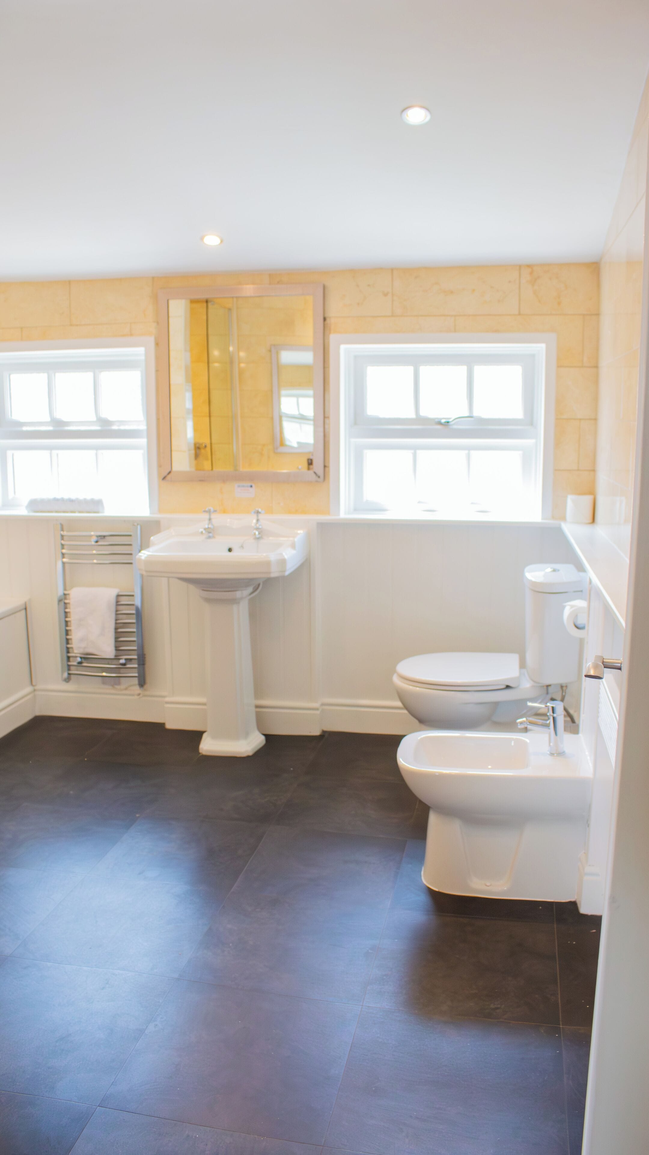 Ein Badezimmer mit Waschbecken, Toilette, Bidet und Handtuchhalter.