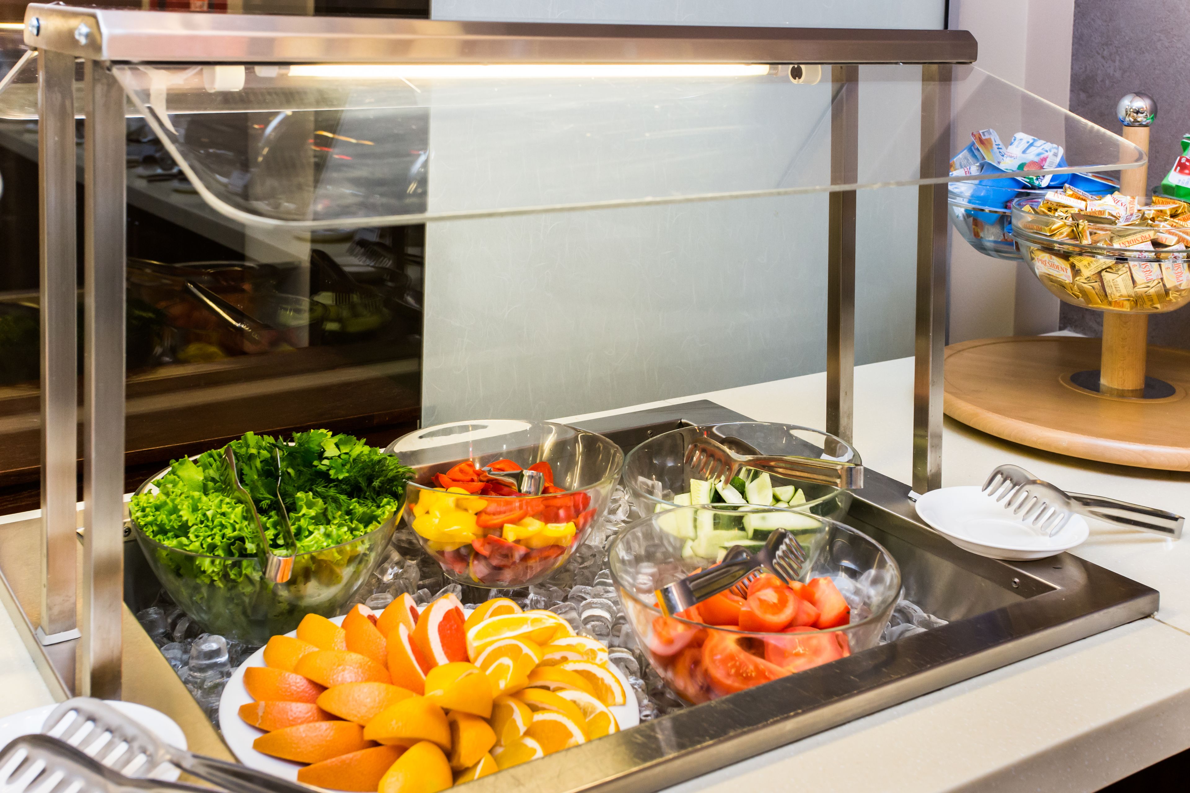 A buffet with various food items including salads, fruits, and vegetables.