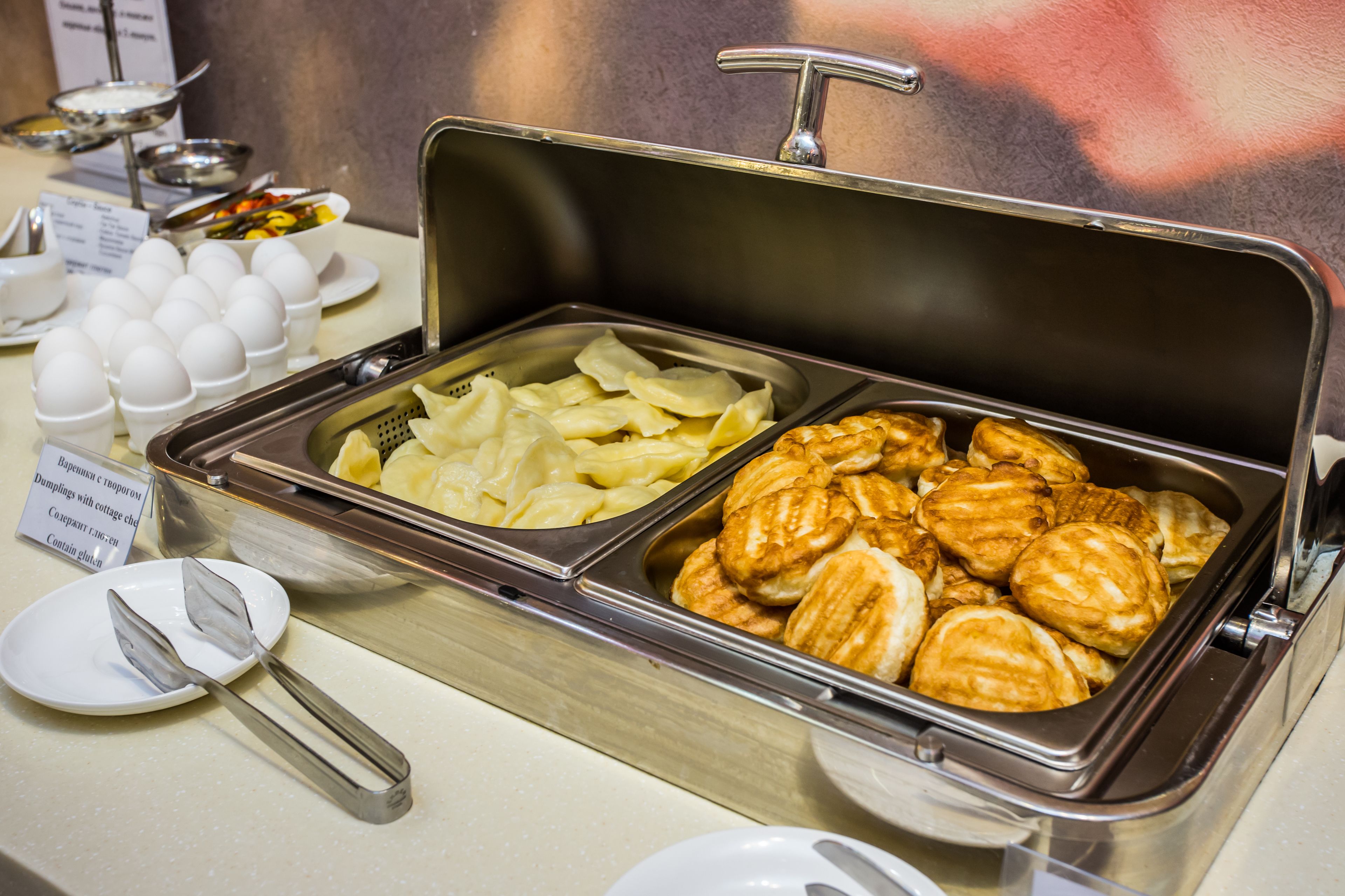 Un bufé con diversos alimentos, como huevos, dumplings y pasteles.