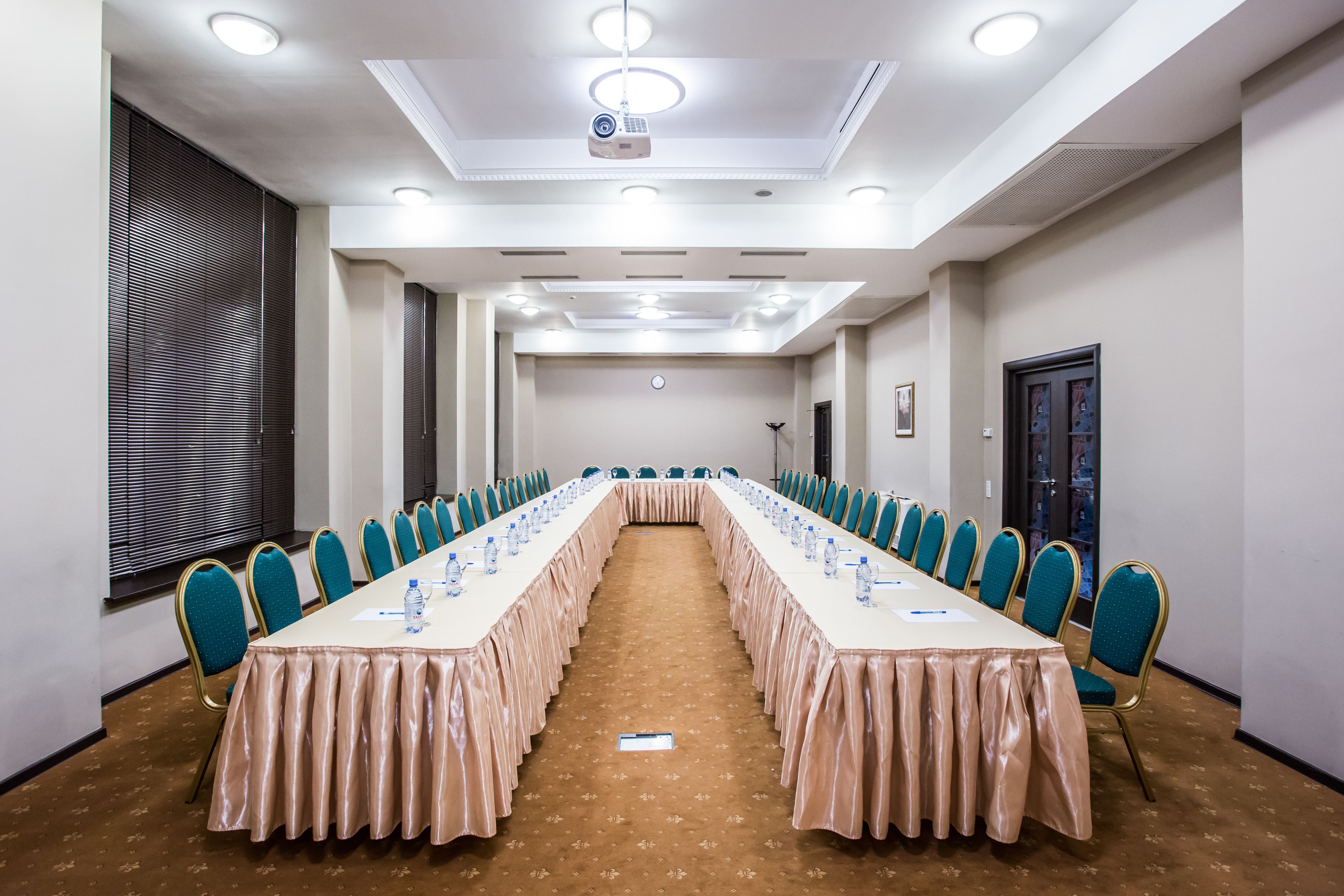 A conference room with a long table, chairs, and a projector.