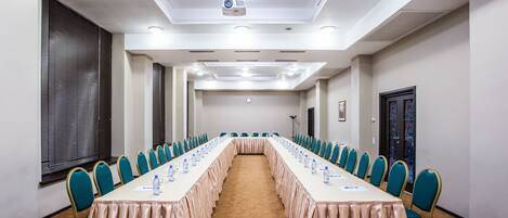 A conference room with a long table, chairs, and a projector.