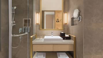 Une salle de bain moderne avec une douche à parois de verre, un lavabo avec un miroir et deux porte-serviettes.