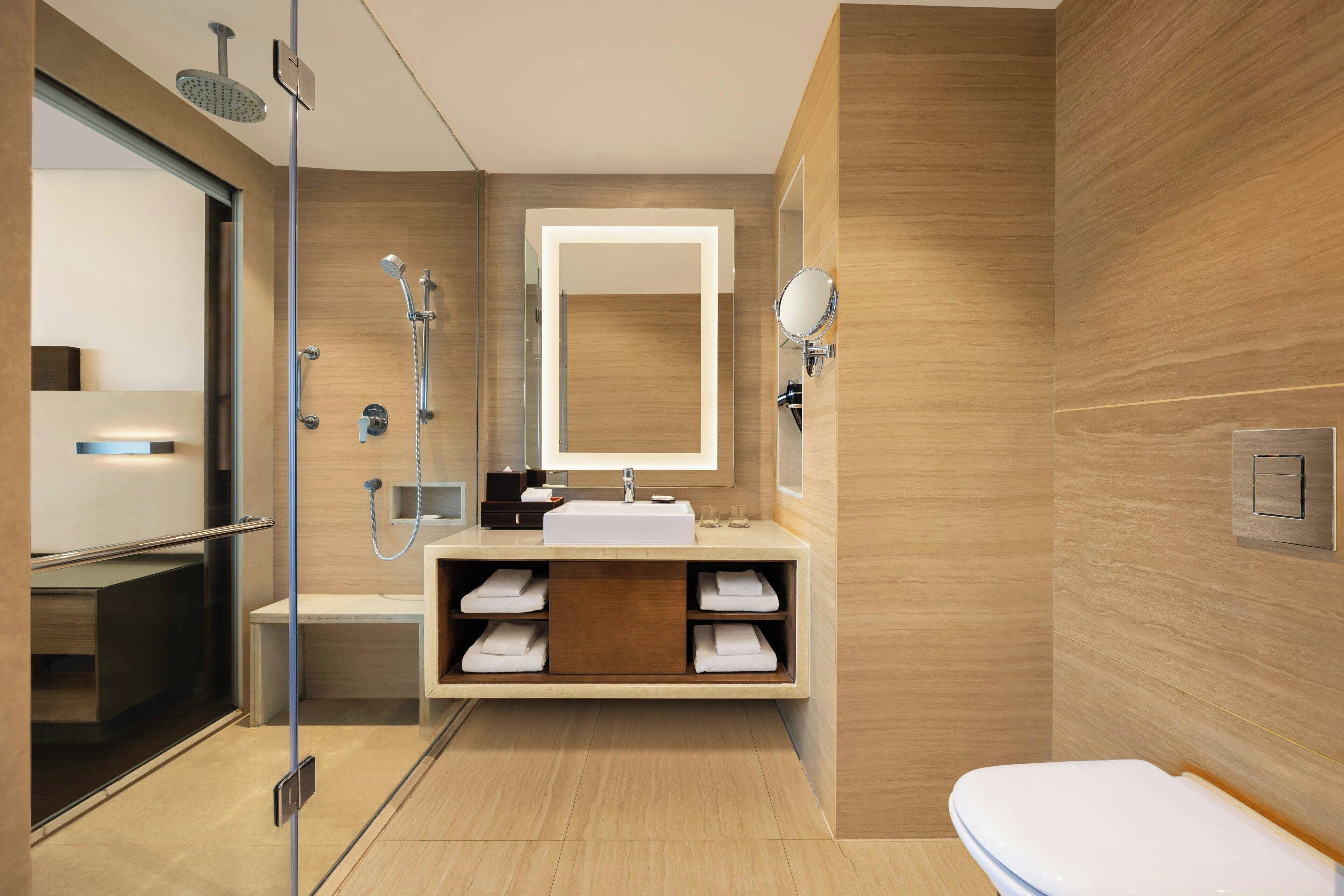 Ein modernes Badezimmer mit Duschkabine aus Glas, integriertem Waschbecken mit Spiegel und Toilette.