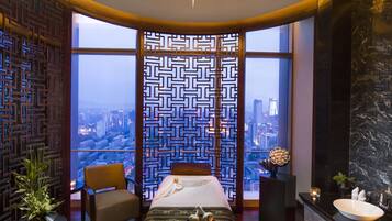 Enjoy a panoramic city view from the large bed, surrounded by a geometric-patterned partition and a unique star-shaped ceiling light.
