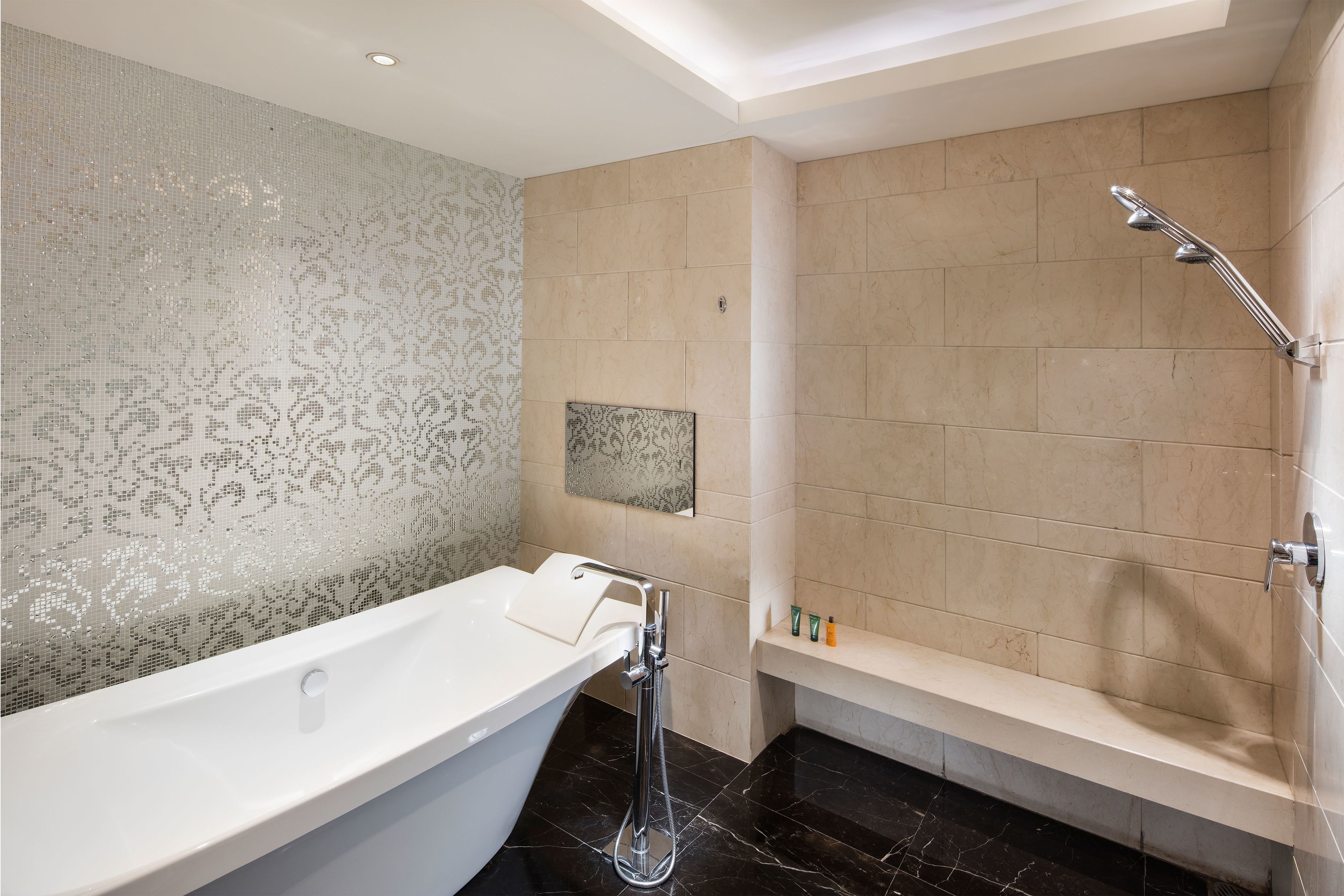 A modern bathroom with a freestanding bathtub, a showerhead, and a vanity with a mirror.