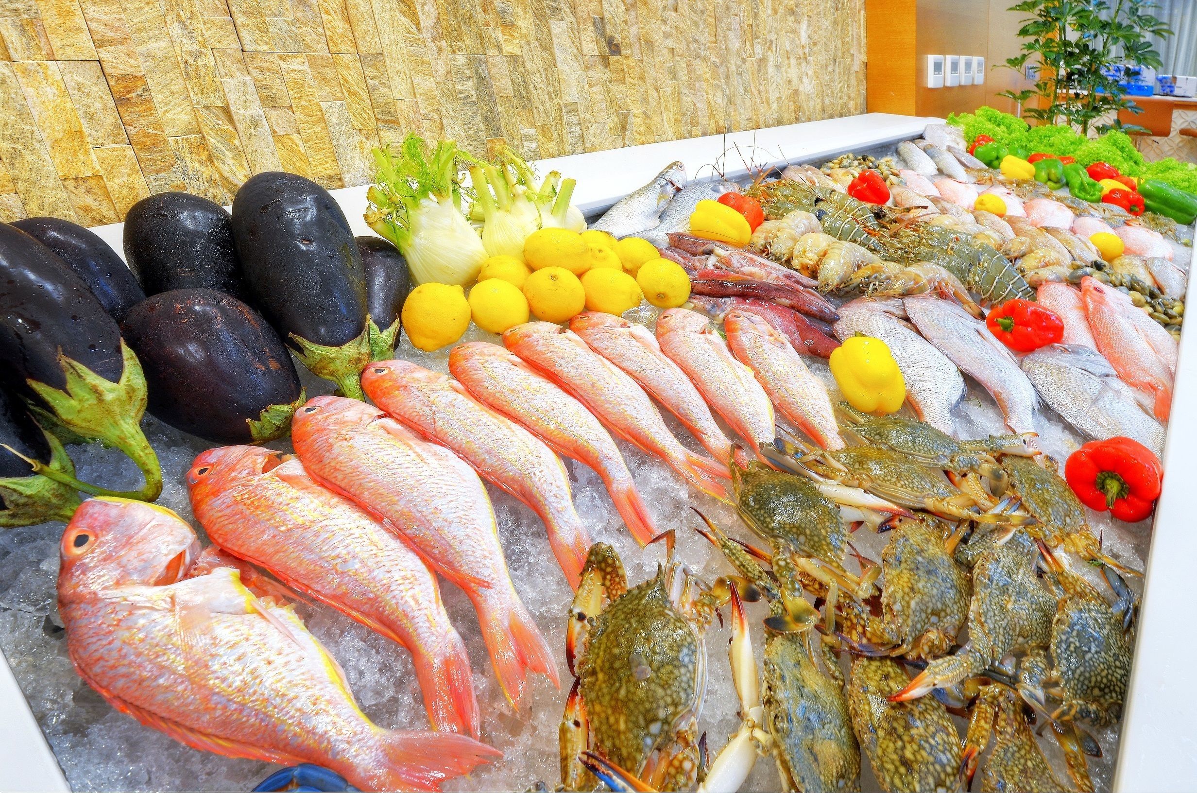 A seafood display with various types of fish and vegetables.