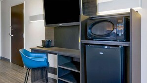 A compact kitchenette with a flat-screen TV, a microwave, and a small refrigerator. - Motel 6 Marble Falls, TX (Marble Falls)
