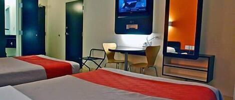 A hotel room with two beds, a desk, a chair, a television, and a mirror.