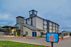 A motel with a modern design, featuring a prominent '6' sign, a satellite dish, and a flat roof. - Motel 6 Marble Falls, TX (Marble Falls)