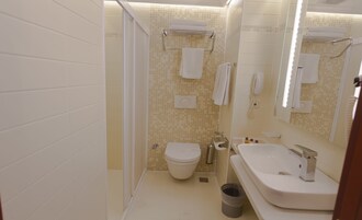 Een kleine badkamer met toilet, wastafel en spiegel.