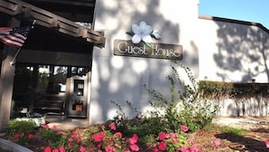 A building with a sign reading "Guest House" and an American flag. - The Inn at Houndslake (Aiken)