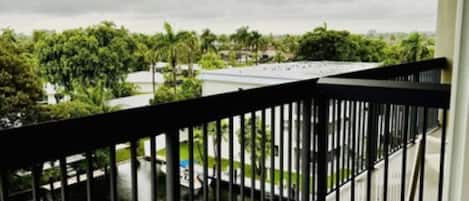 A balcony with a view of a water body and greenery.
