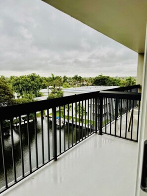 A balcony with a view of a body of water and greenery.