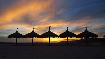 En la playa, camastros y sombrillas