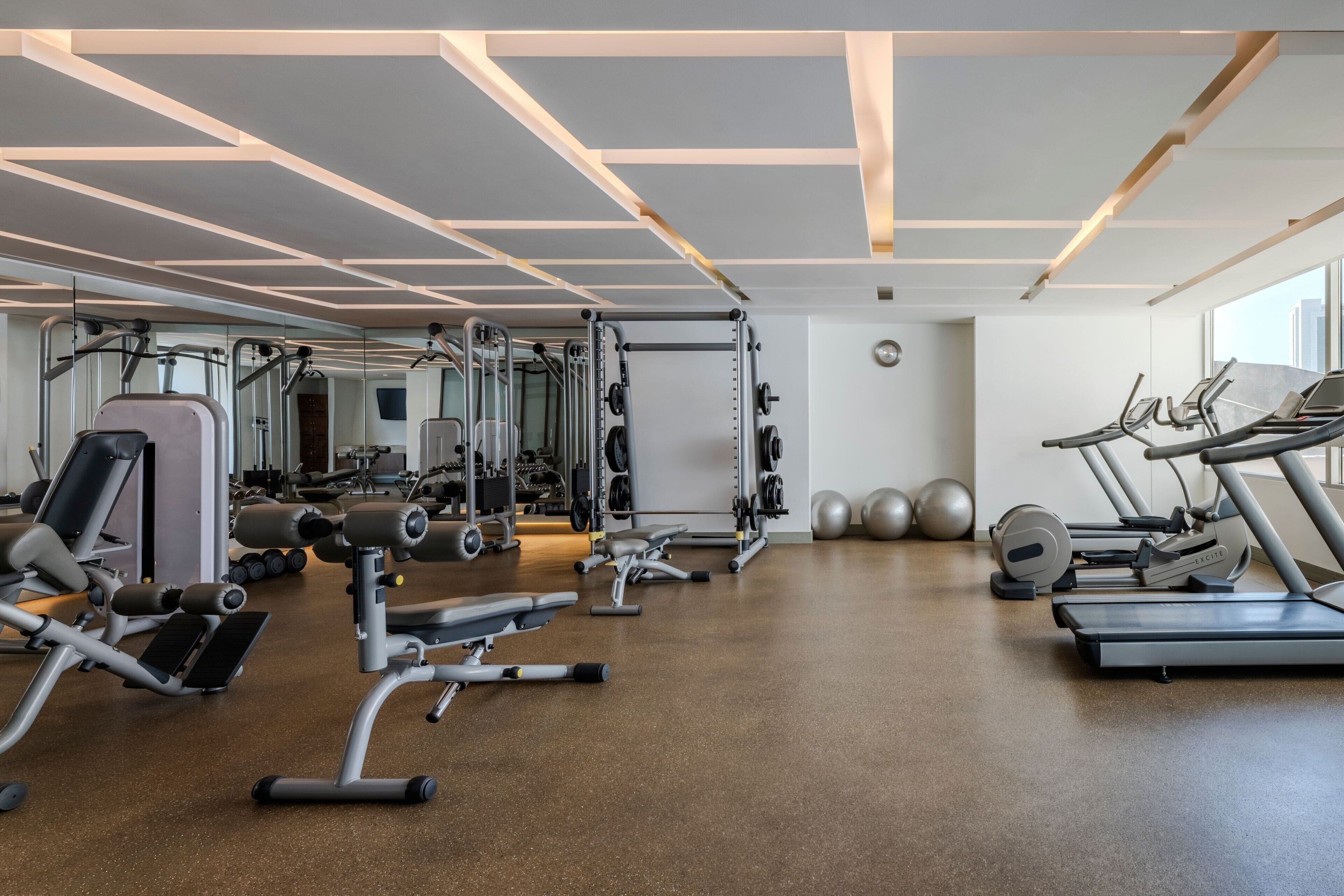A modern gym with various exercise equipment, including treadmills, weight machines, and free weights.