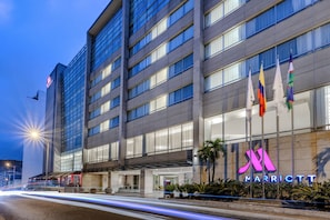 A modern hotel with a prominent 'Marriott' sign, multiple flags, and a well-lit facade. - Cali Marriott Hotel (Cali)