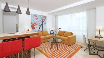 A modern living room with a sofa, coffee table, and dining area.