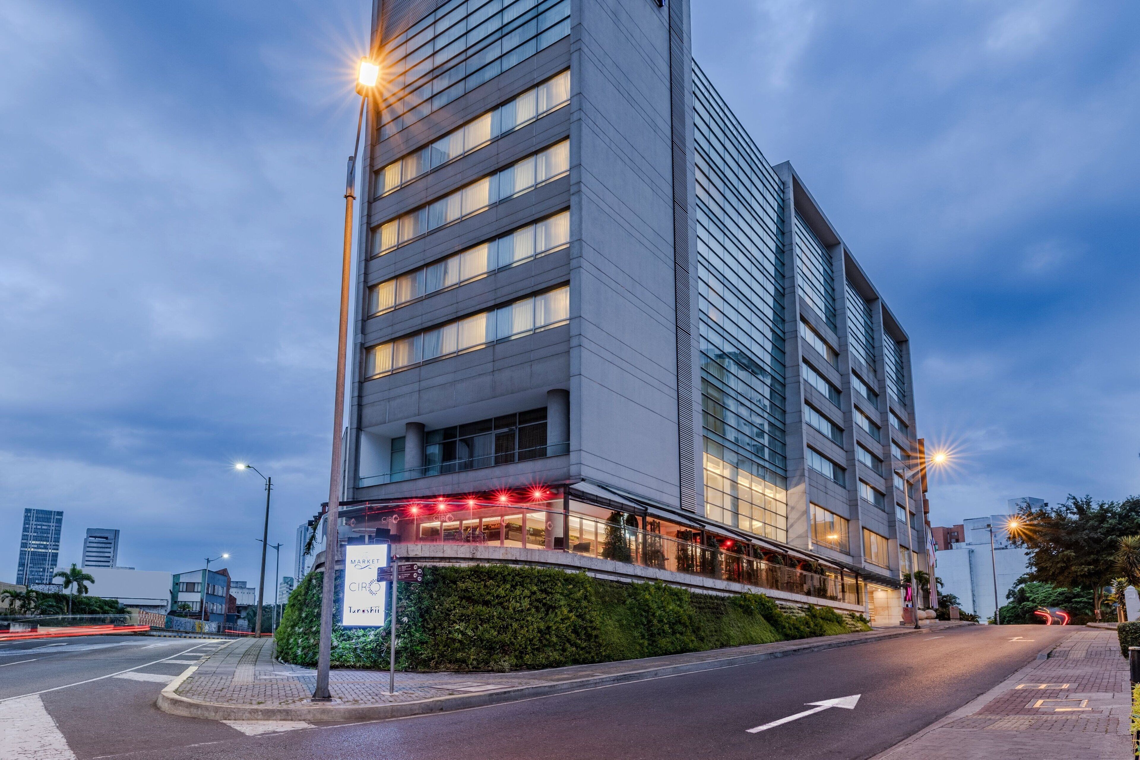 Un hotel moderno con una posizione angolare ben visibile, ampie finestre e un ingresso luminoso.