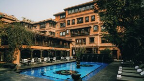 Un área de piscina con sillones de descanso y una fuente.