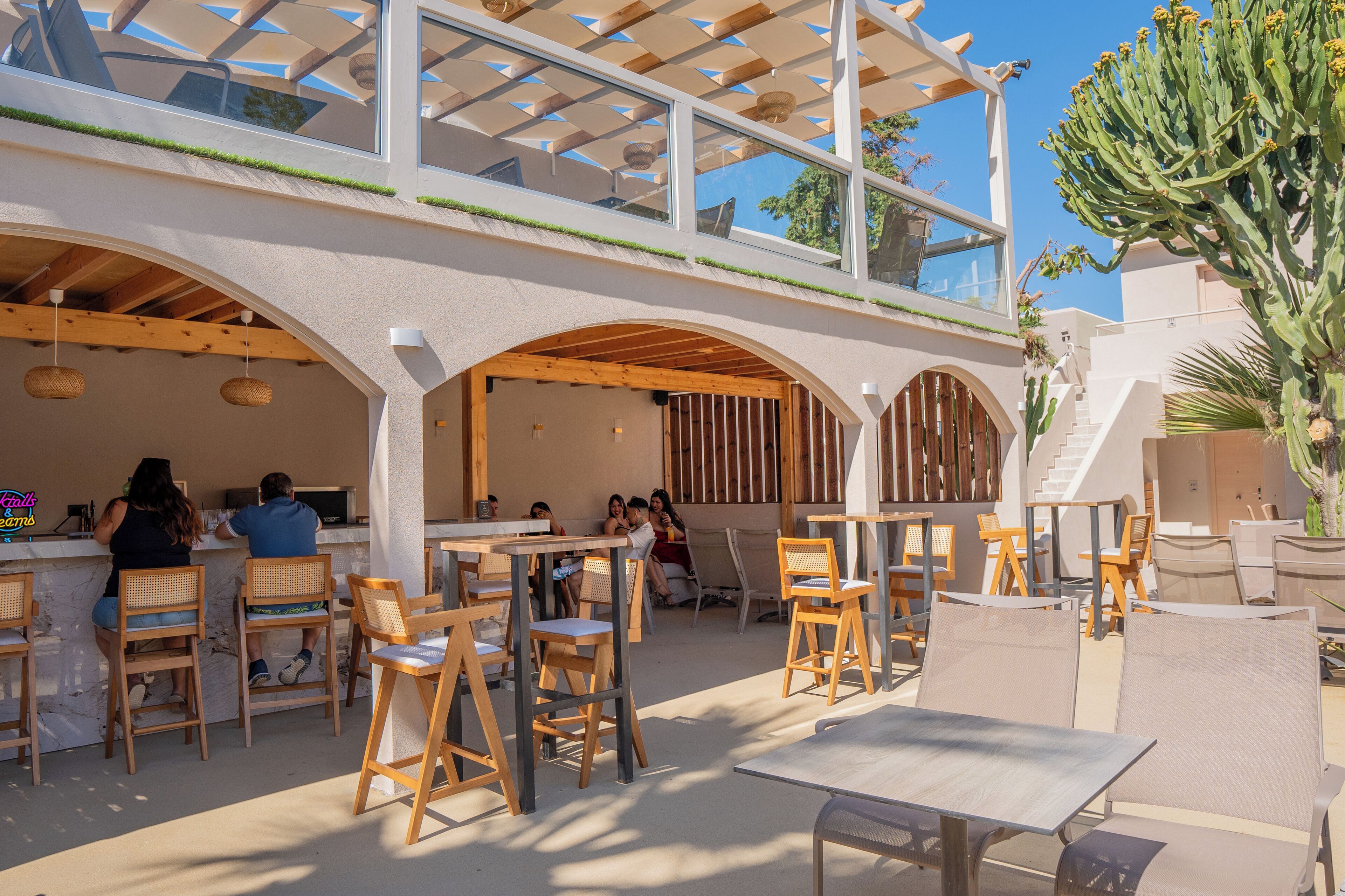 An outdoor dining area with wooden furniture and a covered seating area.