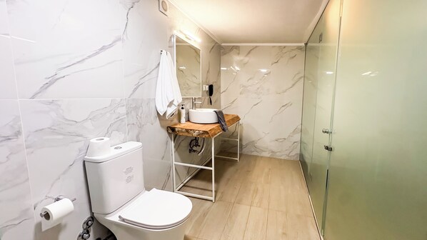 A bathroom with a toilet, sink, and shower.