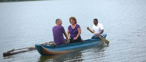 Tres personas en un bote pequeño en un lago tranquilo.