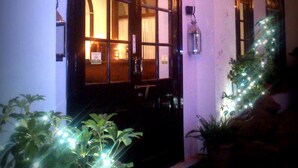 Un edificio con una entrada arqueada, un interior visible a través de las ventanas y luces decorativas.