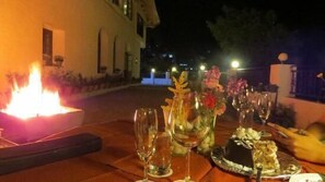 An outdoor dining setup with a table, candles, and a cake. - Ilbert Manor (Dehradun)