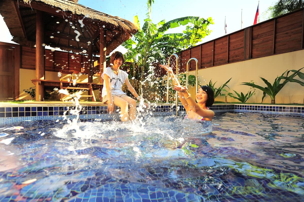 A swimming pool with two people playing in the water.