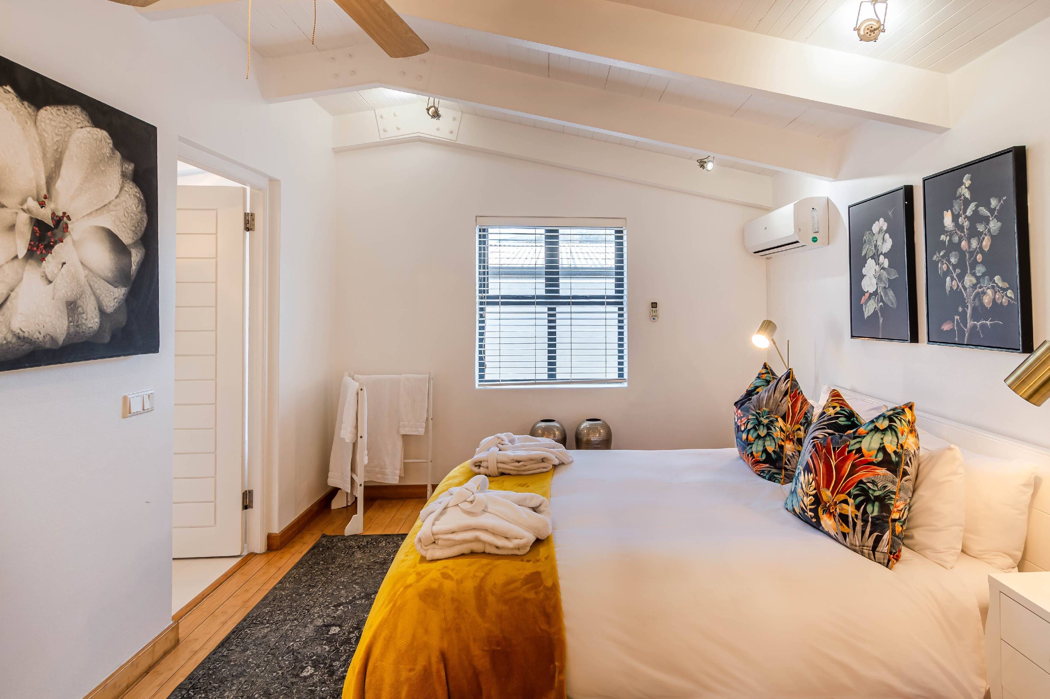 Ein Schlafzimmer mit Bett, einem Fenster mit Jalousien, einer Heizung und einem Bild an der Wand.