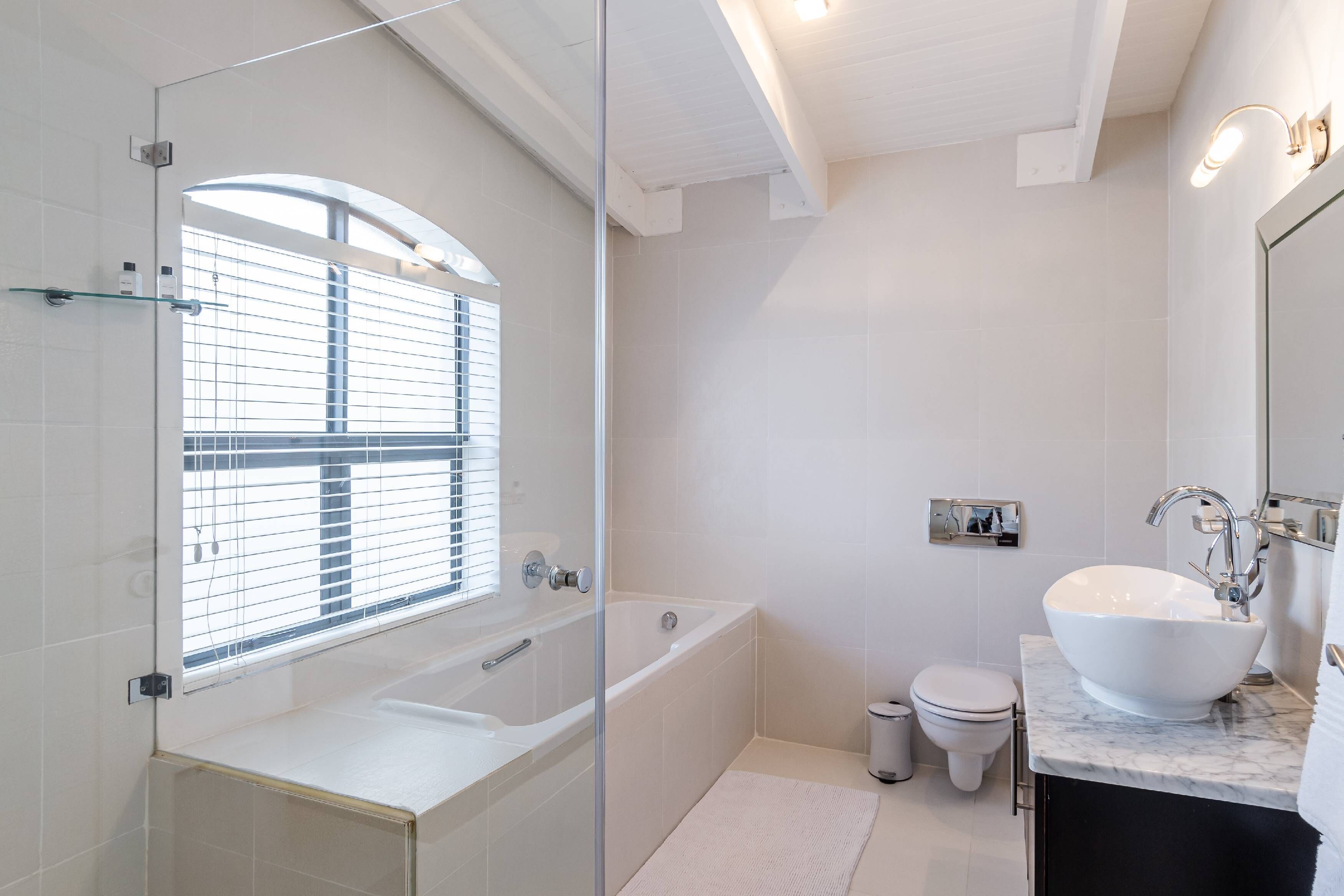A modern bathroom with a bathtub, a large sink, and a toilet.