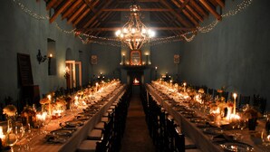 A long banquet table set for a formal dinner with candles and flowers. - Hawksmoor House (Cape Town)