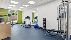 A gym with treadmills, a bench press, and a mirror. - Spark by Hilton Victoria (Victoria)