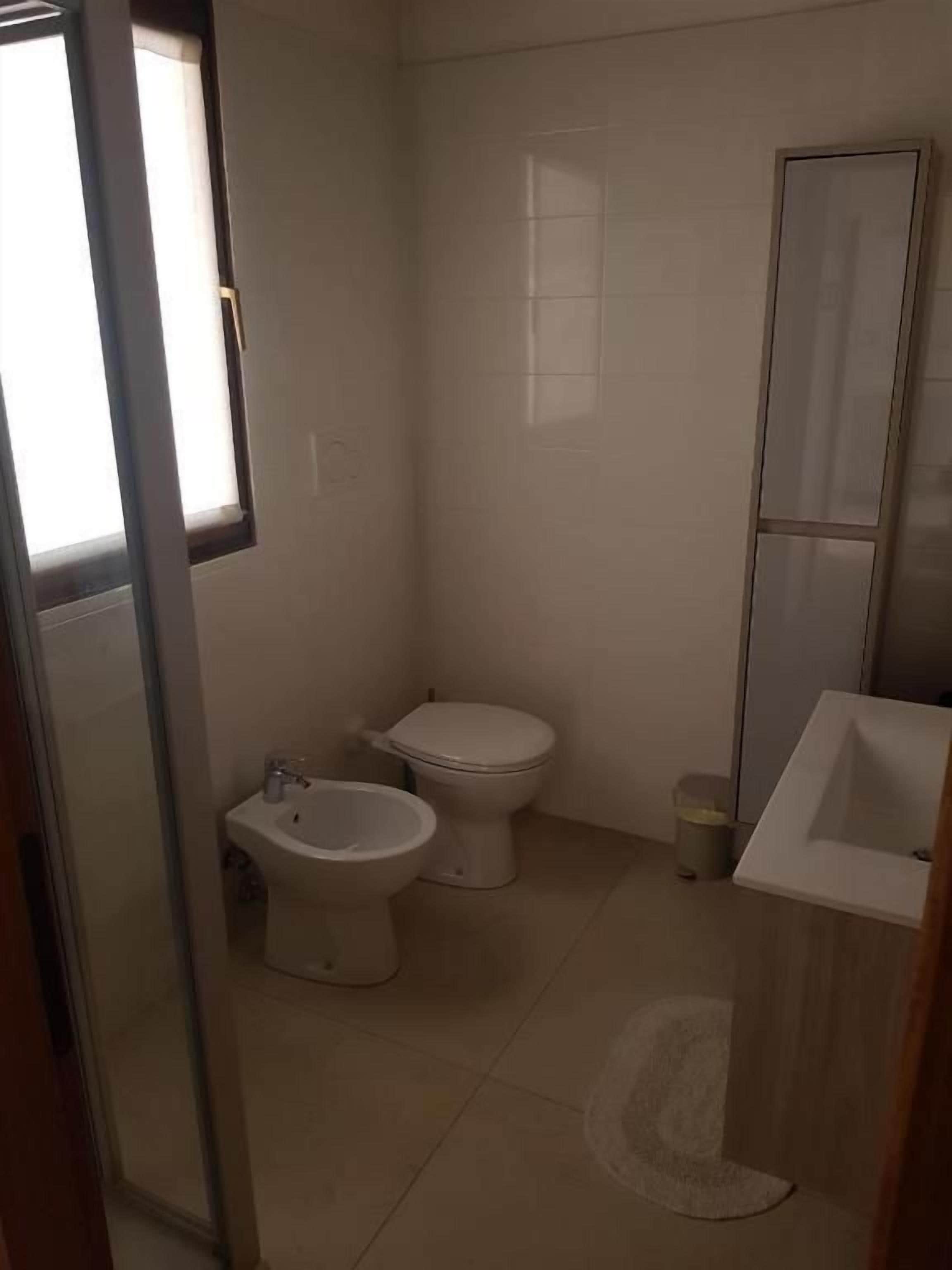 A small bathroom with a toilet, bidet, and sink.