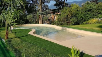 Una piscina al aire libre, sillones reclinables de piscina