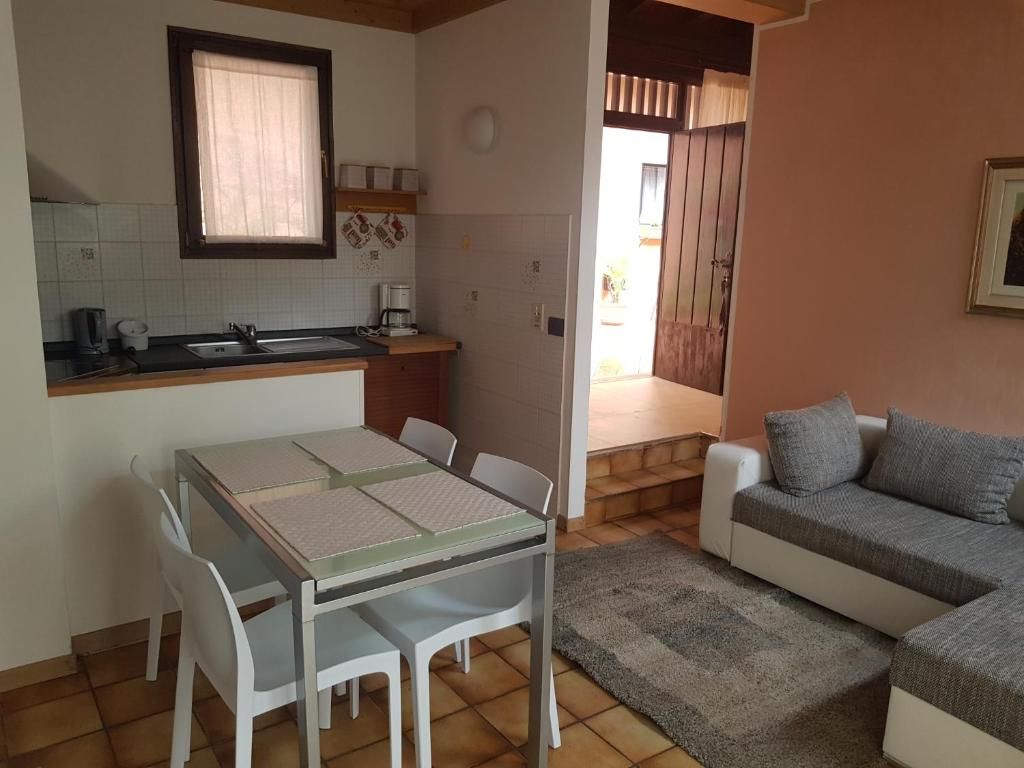 Un espacio habitable compacto con kitchenette, comedor y sofá.