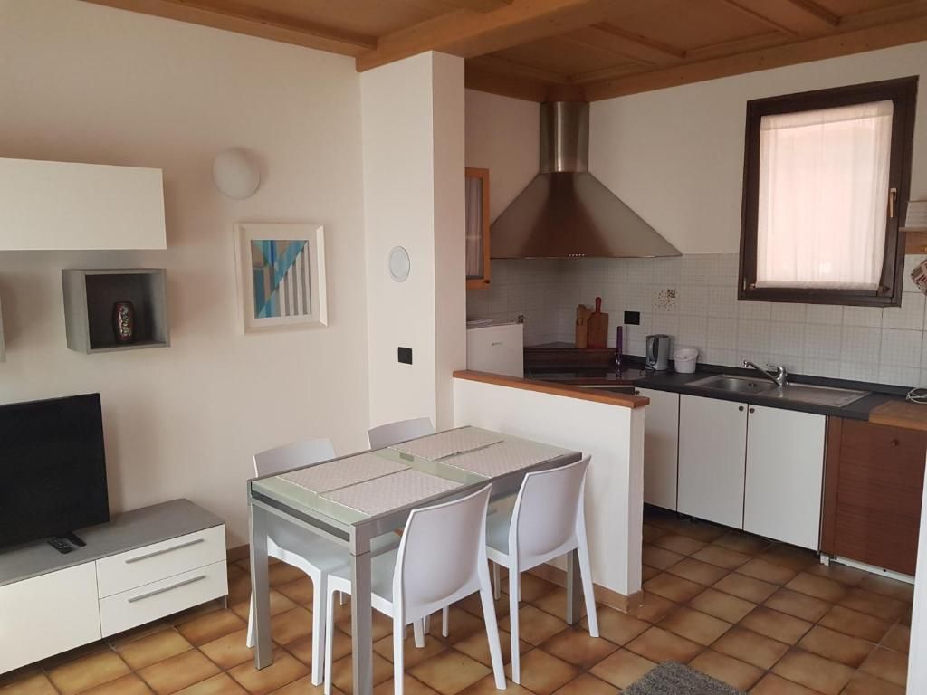 Cocina compacta con comedor, estufa integrada y ventana.