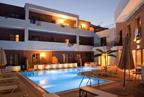 A multi-story hotel with a swimming pool, balconies, and outdoor seating areas. - Hotel Stella Katrin (Rethymno)