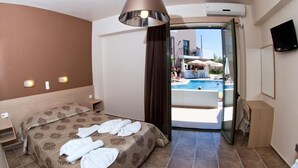 A hotel room with a bed, bedside tables, a TV, and a view of a swimming pool. - Hotel Stella Katrin (Rethymno)