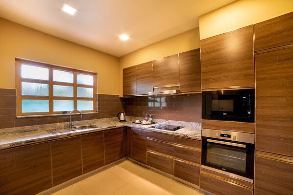 A modern kitchen with wooden cabinets, a stainless steel sink, and a built-in oven.