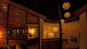 A cozy wooden interior with a sofa, a wooden railing, and hanging spherical lights. - Speke Resort & Conference Centre (Kampala)