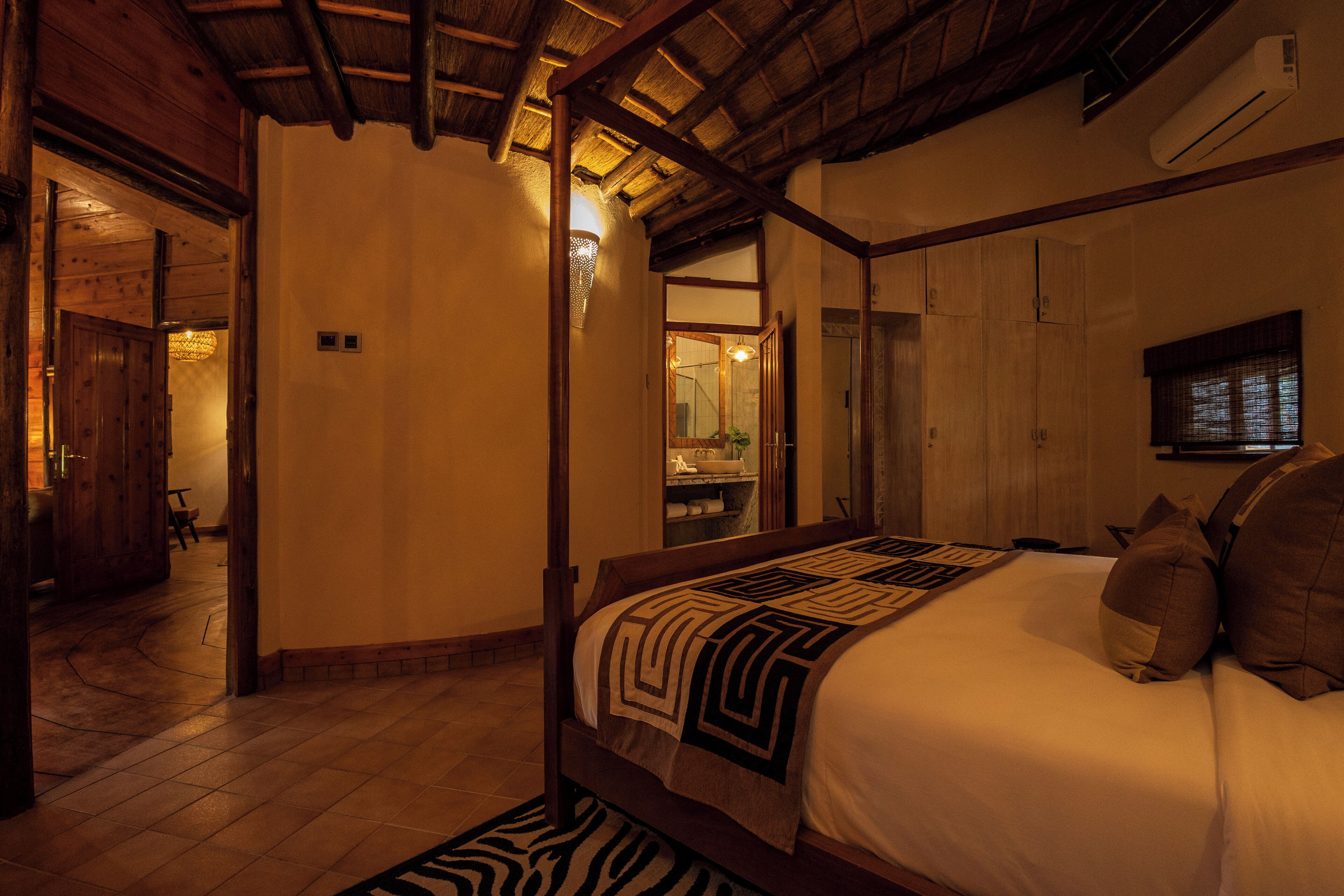 Ein Schlafzimmer mit einem Bettgestell aus Holz, einem Teppich mit ZEBRA-Muster und einer Holzziel.