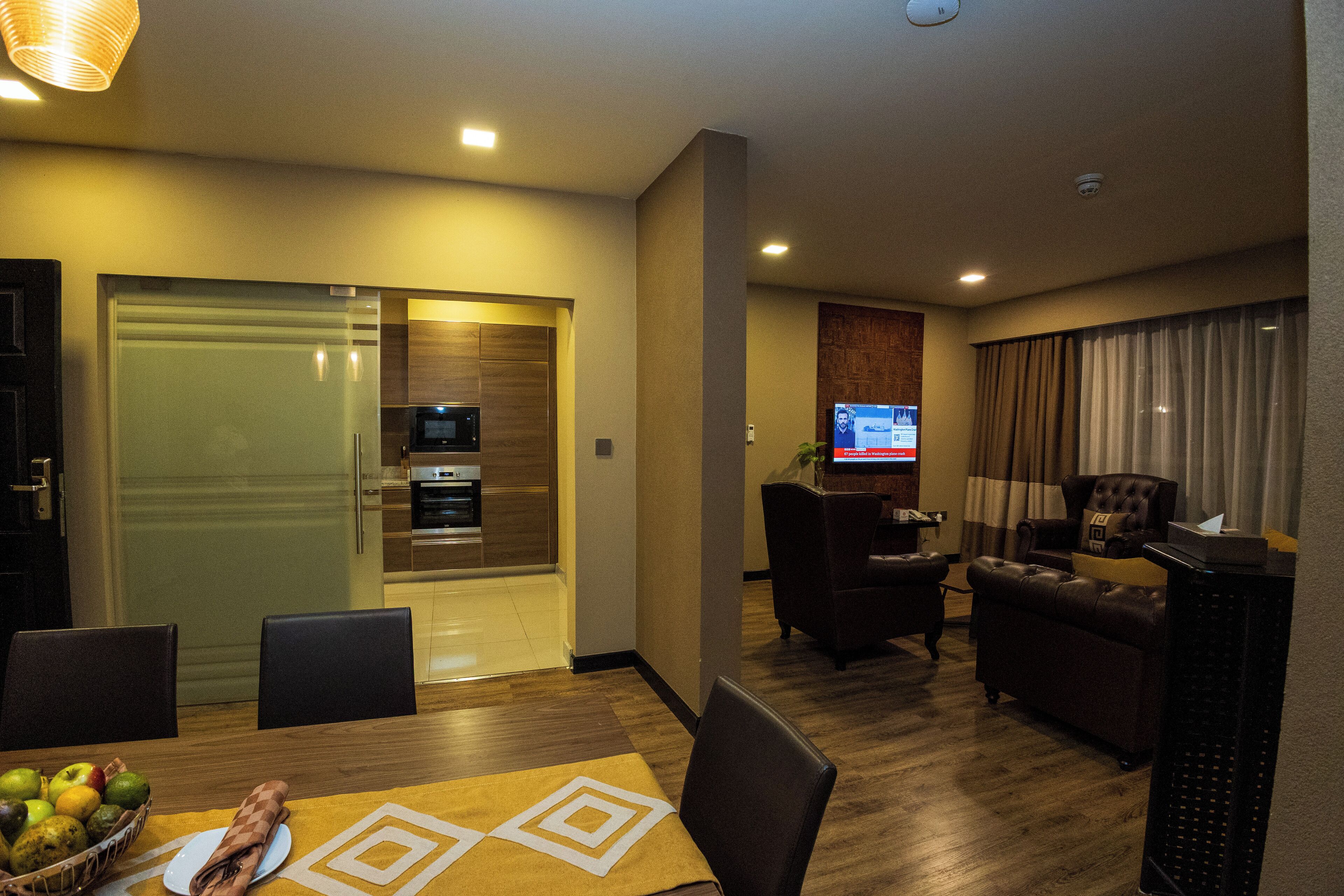 Una sala moderna con comedor, cocina y televisor.
