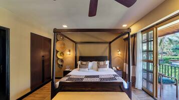 A four-poster bed with a headboard, bedside tables, and a view of the outdoors.