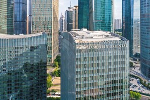 A modern high-rise building with a glass facade and the name "MANDARIN ORIENTAL" on the top.