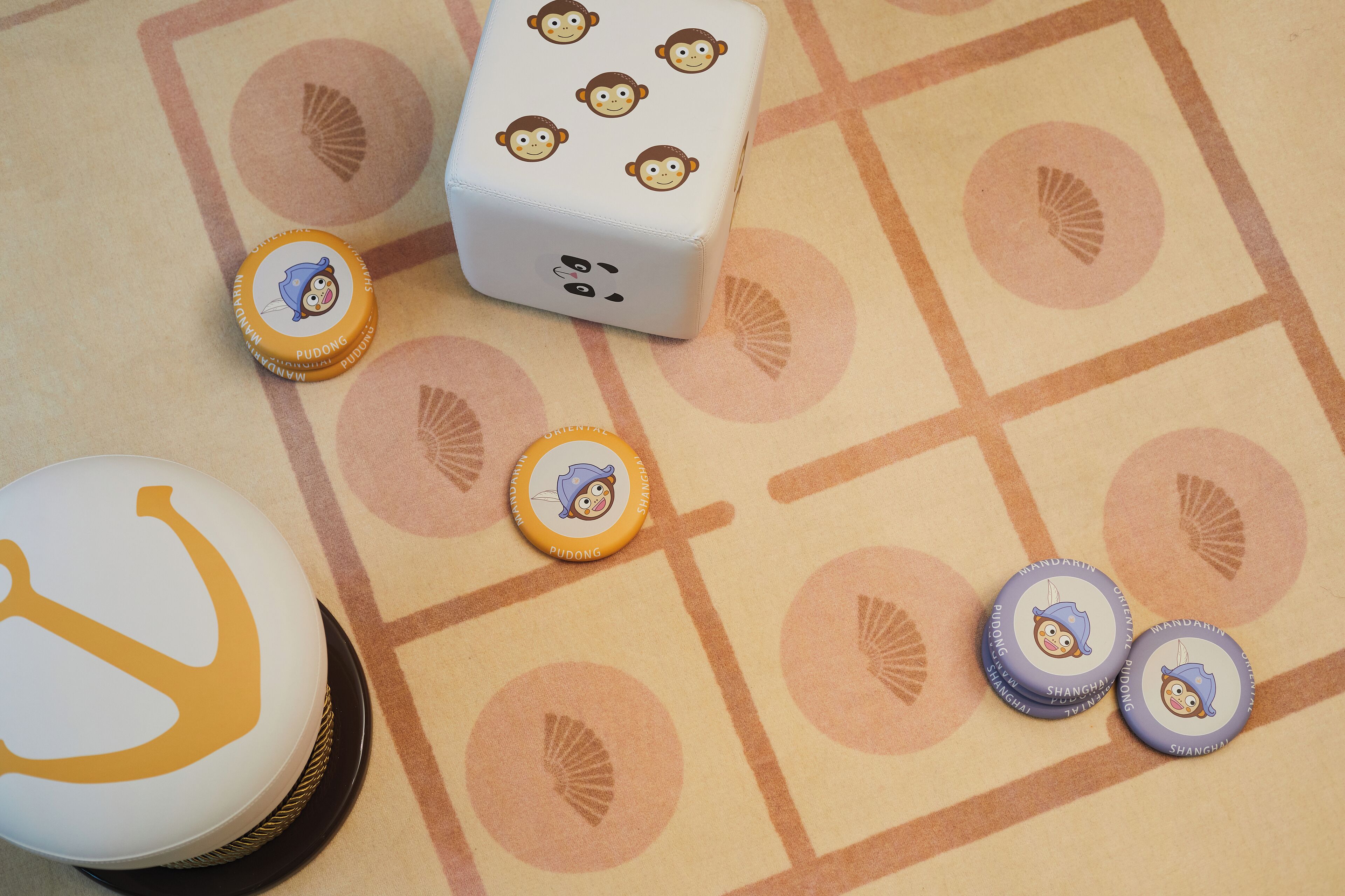 A table with a white object featuring cartoon monkey faces, a white object with a yellow design, and several round objects with cartoon monkey faces.