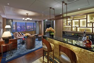 A modern hotel lobby with a bar area, seating, and a view of the cityscape.