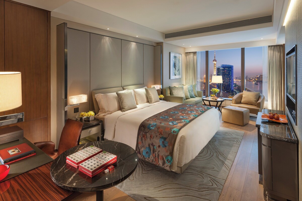 Une chambre d’hôtel moderne équipée d’un grand lit, d’un bureau, d’une chaise et d’un téléviseur.
